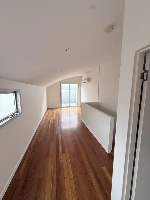 Living area with white walls and sloping ceiling