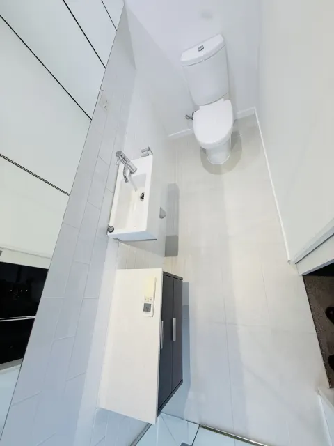 Bathroom with white tiles and dark vanity