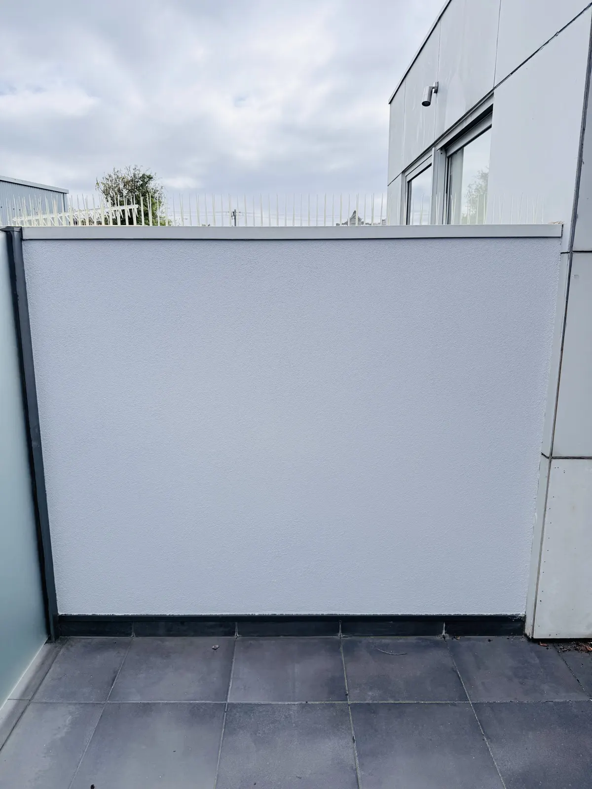 Rendered exterior wall with contrasting dark trim — from our Bayside projects.