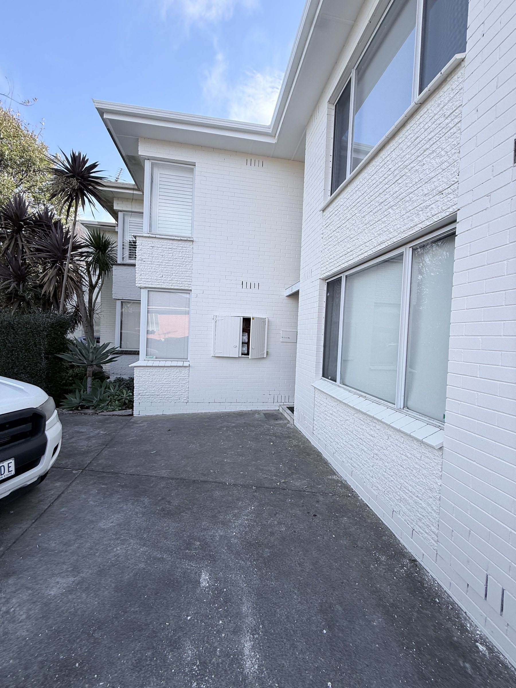 Full building exterior repaint in Bentleigh with fresh white brickwork and window trim